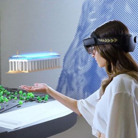 A woman that wears a VR headset is enjoying a mixed reality of Ancient Olympia