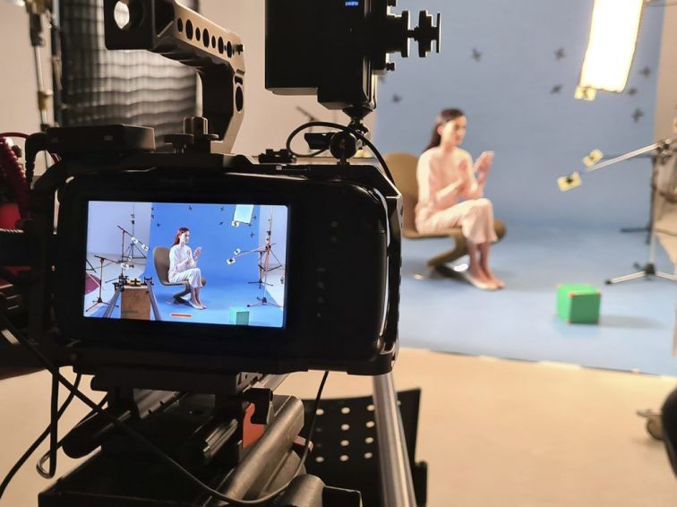 A behind the scenes view of a blue-screen shooting of a girl